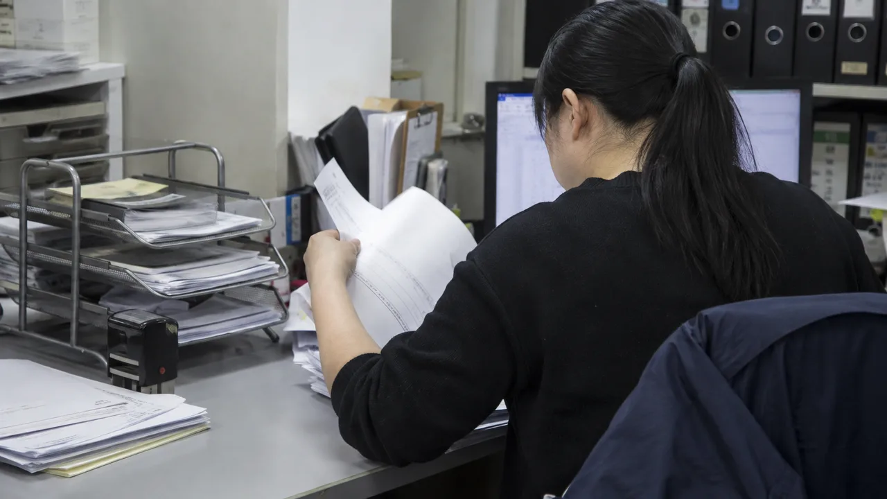 行政人員在工作台核對送貨單