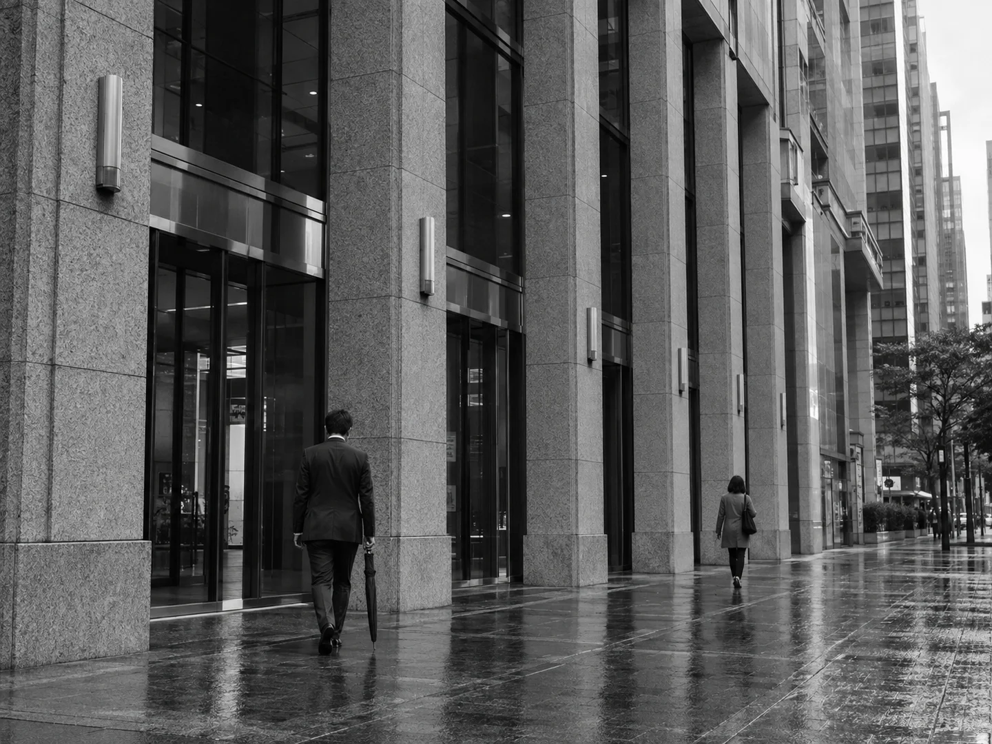 Black-and-white street view of a financial district building after rain